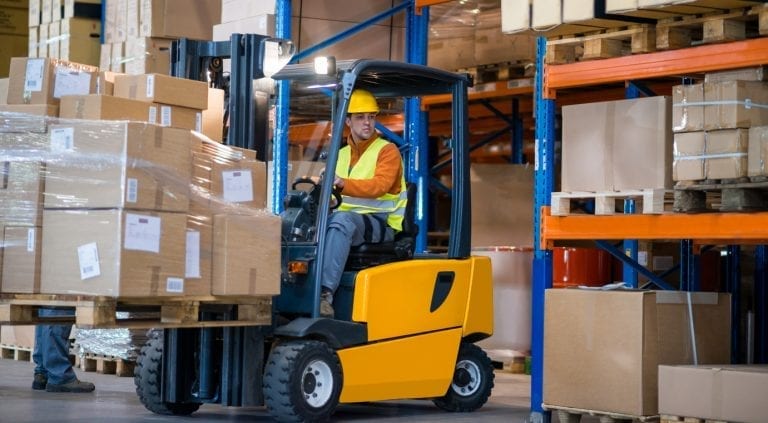 warehouse worker moving boxes with a forklift