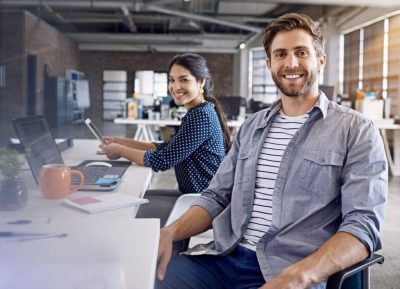 Two professionals sitting with business casual attire.