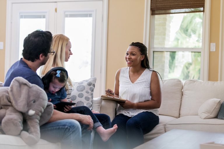 african-american counselor talking to the parents of a young child during a consultation