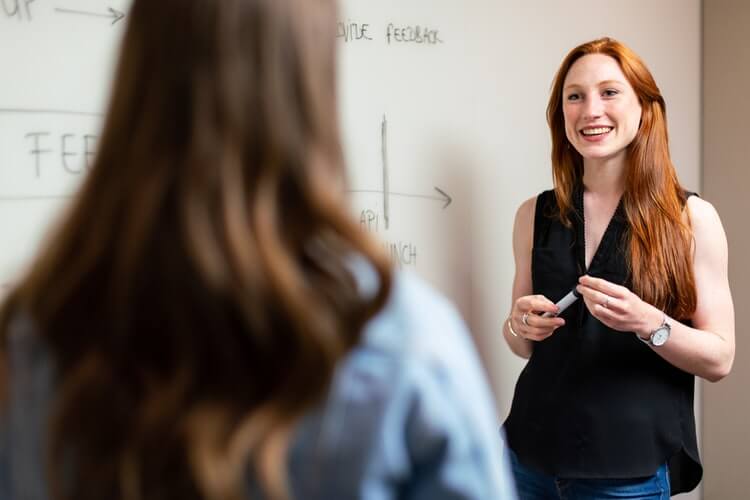 A professional working in front of a white board.